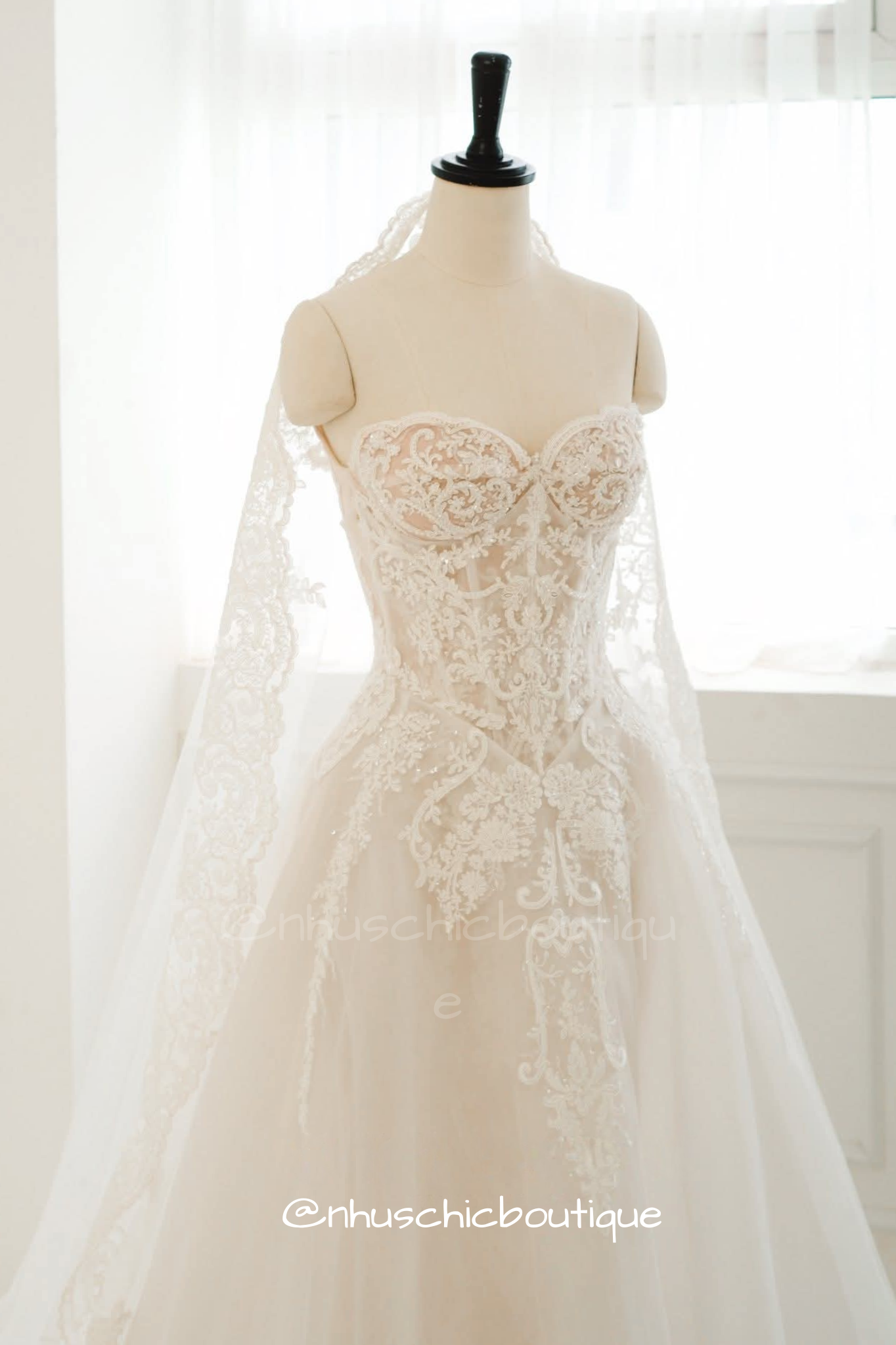 Close-up of the 4-in-1 bridal gown bodice styled with a soft sheer tulle A-line overlay skirt and matching lace-trimmed veil from Nhuschicboutique.