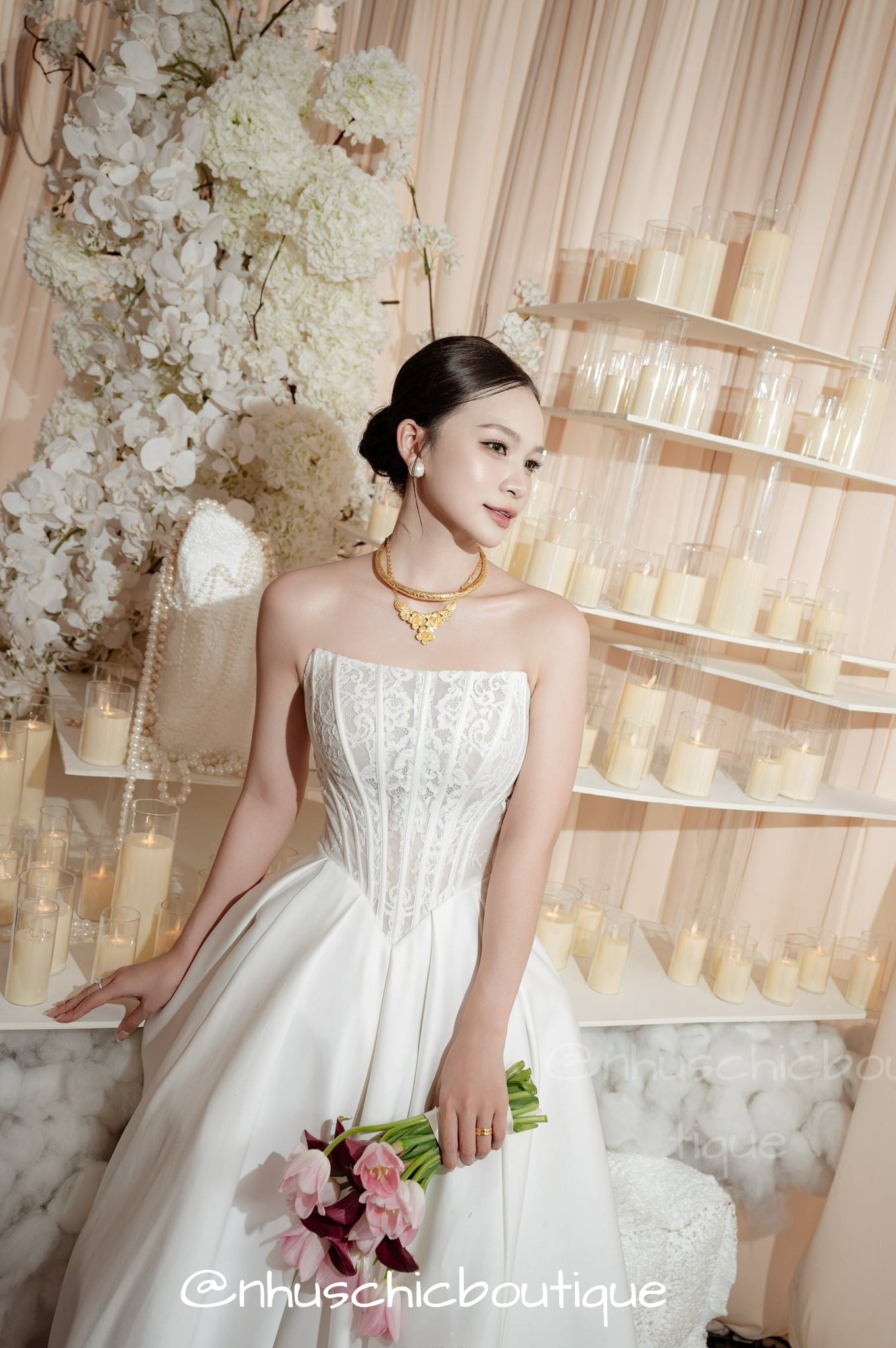 Three-quarter view of bride wearing a custom-made satin wedding dress with a cinched lace corset waist.